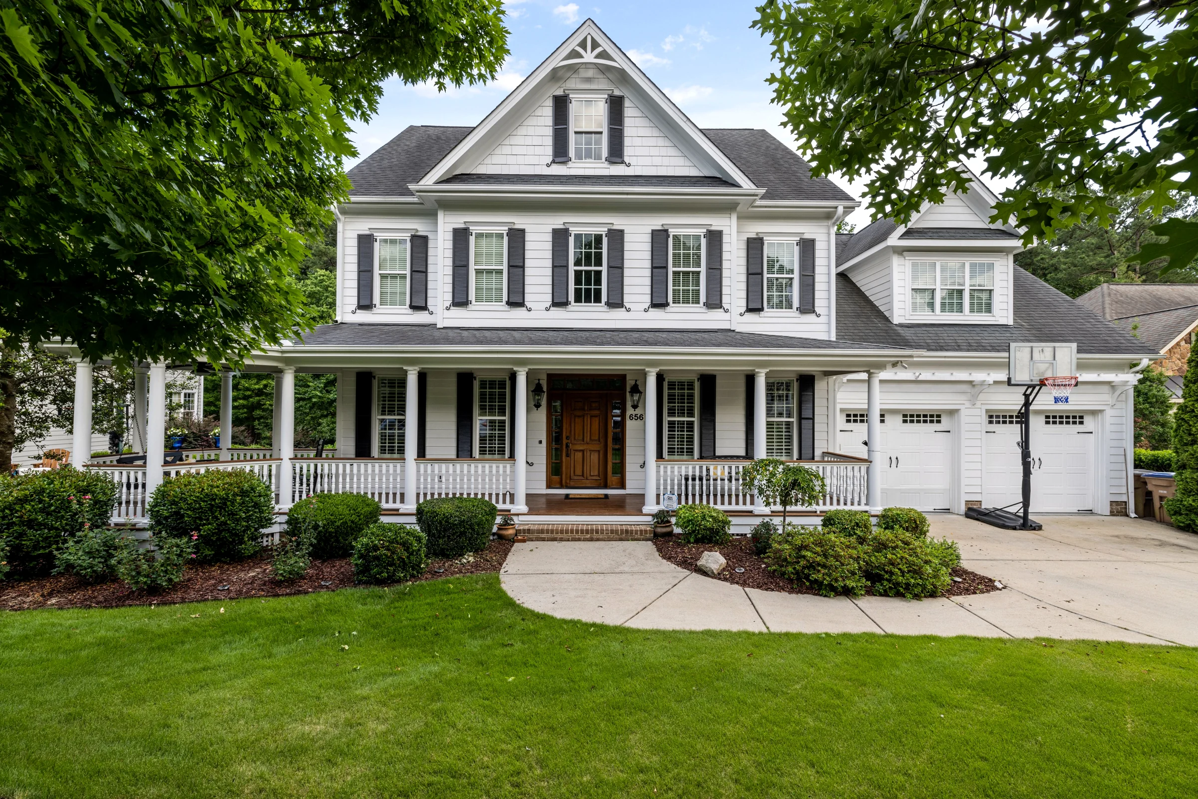 Bright white home with a wide double garage door and landscaped front yard